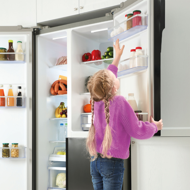 Little girl reaching for eggs in state of the art domestic refrigerator